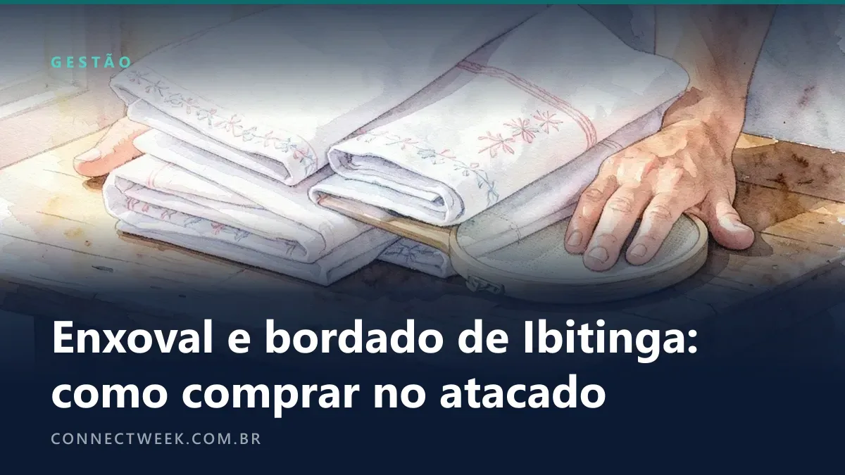 Aquarela de lençóis e toalhas brancas dobradas com bordados em rosa e azul-celeste sobre mesa de madeira com um bastidor
