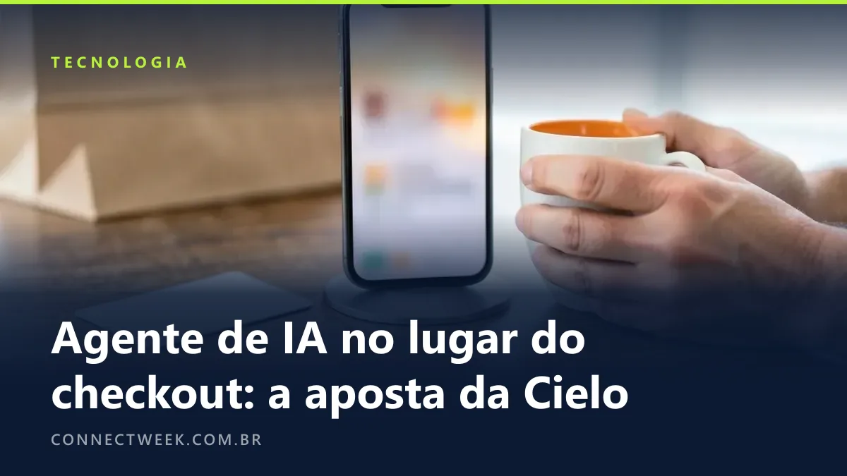 Celular em pé num suporte sobre a mesa, com a tela acesa e desfocada, enquanto as mãos do dono seguram uma xícara ao lado, sem tocar no aparelho nem no cartão largado na mesa