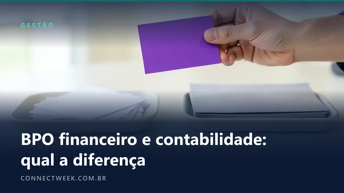 Uma mão segurando no ar um pequeno cartão roxo liso entre duas bandejas de mesa, a da esquerda com papéis brancos soltos e a da direita com pastas cinza arrumadas