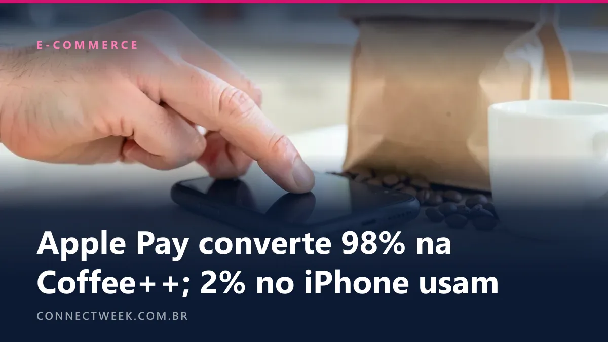 Dedo indicador tocando a tela de um celular sobre uma mesa de cozinha, ao lado de um pacote de papel kraft com grãos de café espalhados e uma xícara branca
