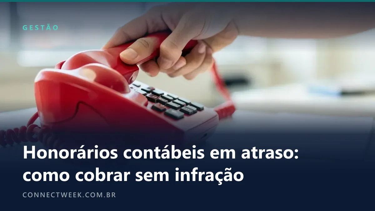 Mão levantando o fone de um telefone de mesa vermelho num escritório, com um bloco de papel em branco ao lado