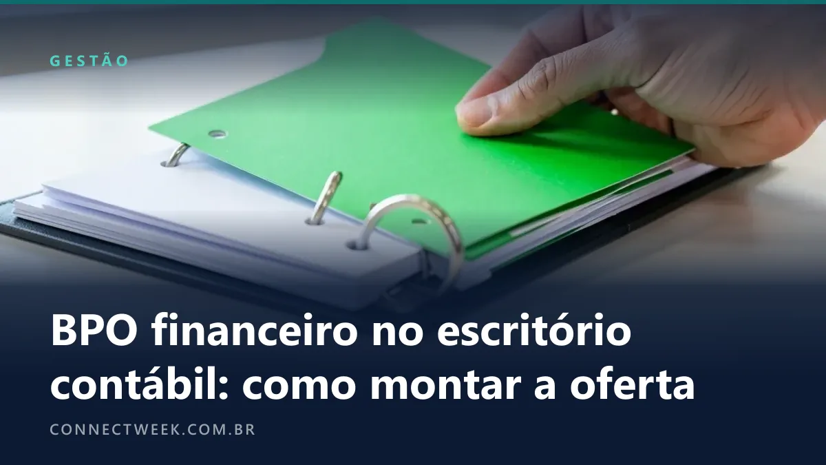 Mão assentando uma divisória verde nas argolas metálicas de um fichário aberto sobre a mesa, por cima de folhas brancas