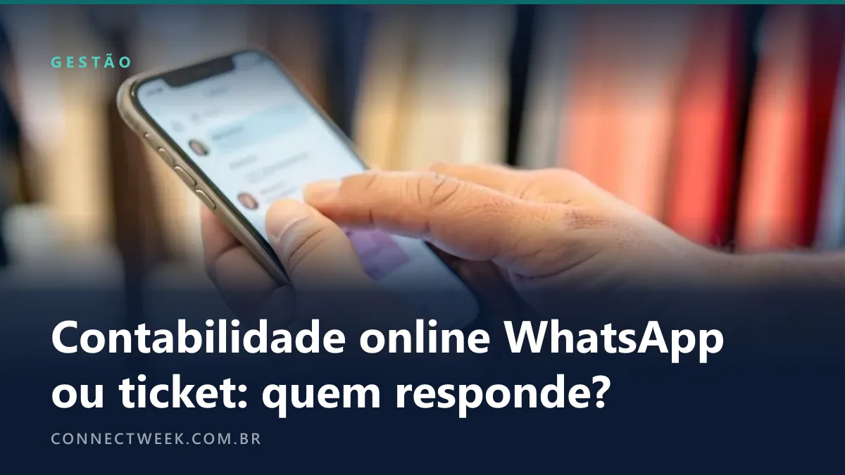 Mãos de lojista digitando num celular com conversa desfocada entre araras de roupas de uma boutique