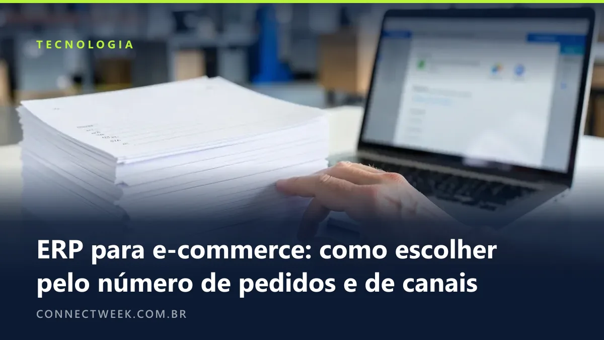 Pilha de folhas de pedido impressas em branco ao lado de um notebook com sistema de gestão desfocado, mão contando as folhas