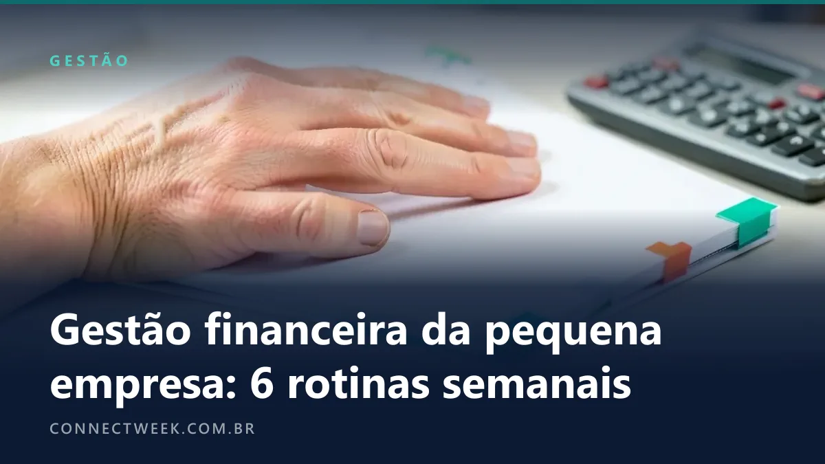 Mão colando a sexta de seis abas coloridas na borda de uma página de planejador em branco, sobre a mesa de uma pequena empresa