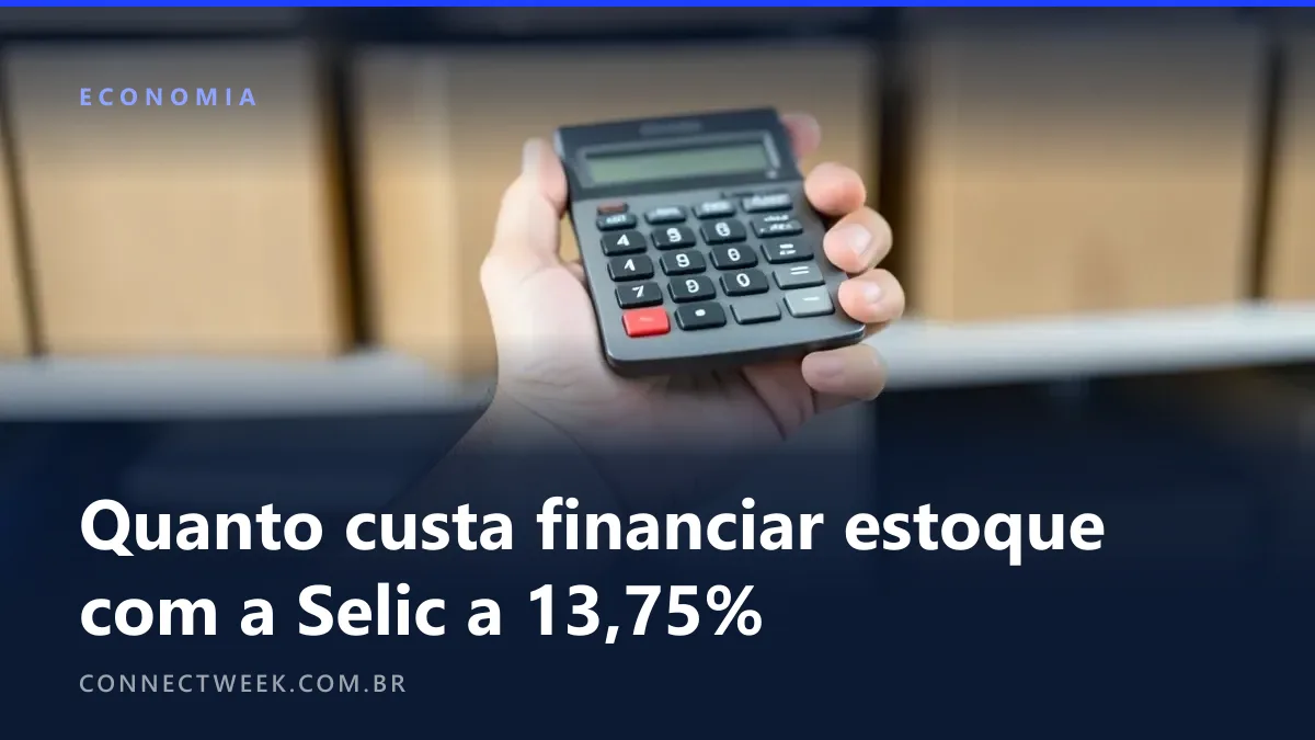Mão segurando uma calculadora diante de uma prateleira de estoque cheia de caixas de papelão