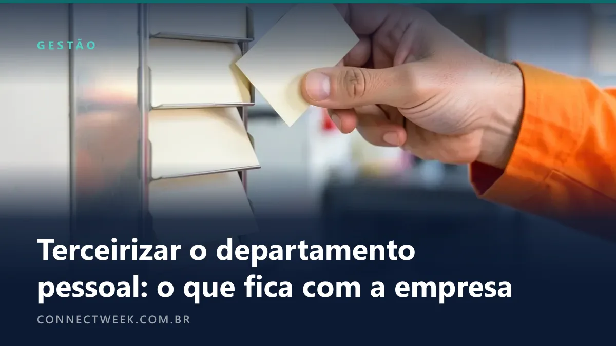 Mão de trabalhador com manga laranja encaixando um cartão de ponto em branco num porta-cartões metálico de parede com outros cartões nos escaninhos