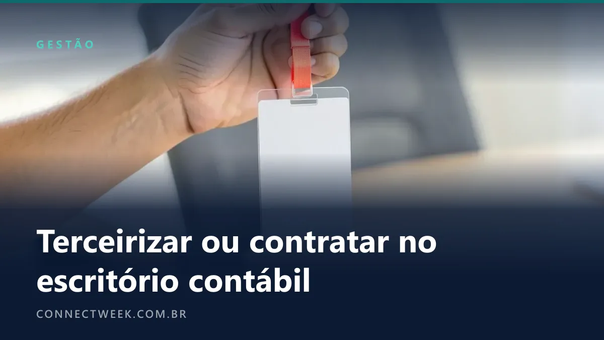 Mão segurando por uma fita coral um crachá em branco, com um escritório desfocado ao fundo
